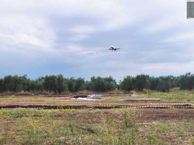 Ci troviamo in aperta campagna, in una vasta piana circondata da alberi di ulivo. Tra una serie di avvisi di lavori in corso ecco che ci appare il villaggio